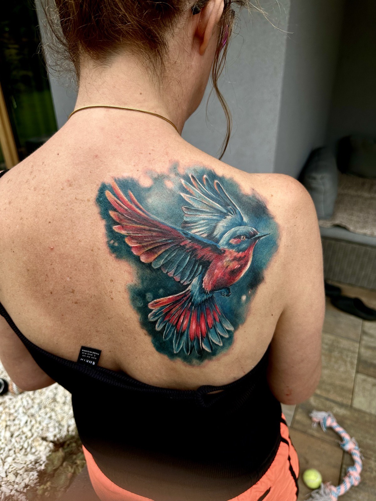 Kolorowy tatuaż ptaka w technice watercolor na plecach
